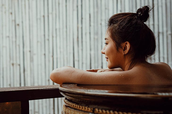 Woman sitting in an onsen looking out.